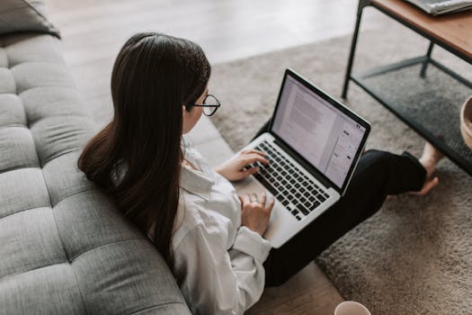A college student studying late at night with a laptop and textbooks, using online assignment help services to finish an assignment